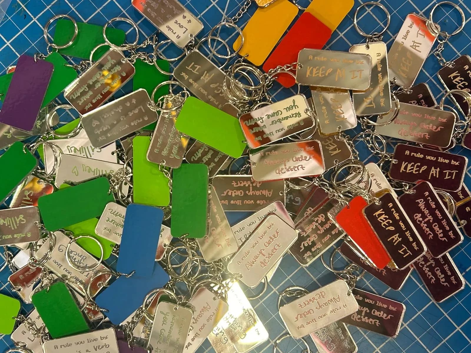 pile of keychains with different quotes/colors
