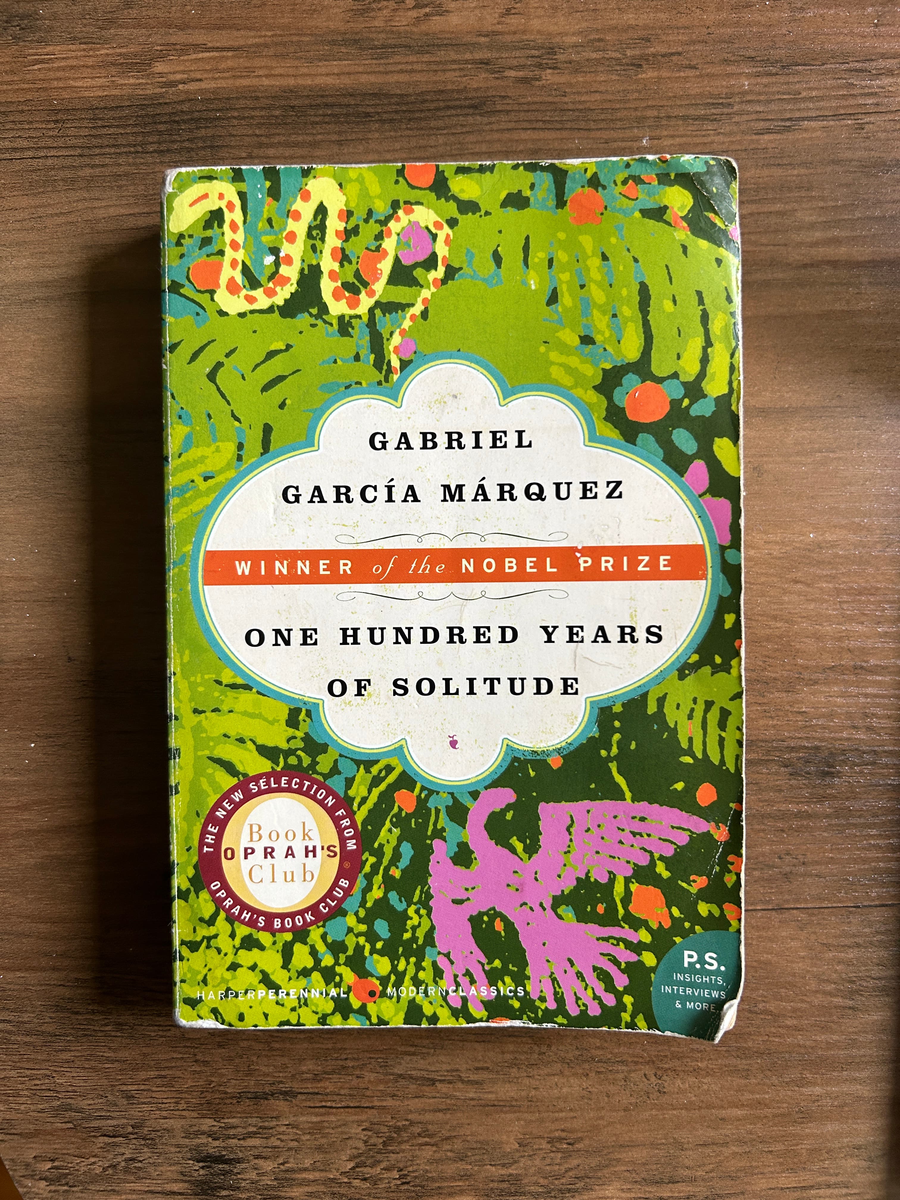 secondhand copy of one hundred years of solitude sitting on a wooden table